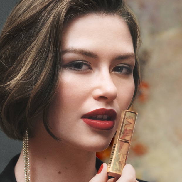 Close up of model applying Crushed-Oil Infused Gloss to lips